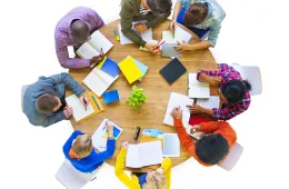 Group of adults sitting around a table with documents on it