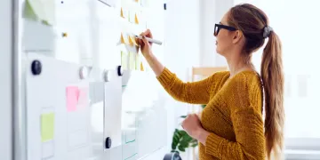 Woman writing on a white board 