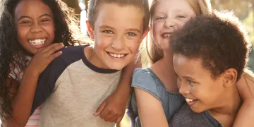 Diverse group of young boys and girls hugging