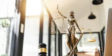 Gavel, lady of justice statue, books in an office space