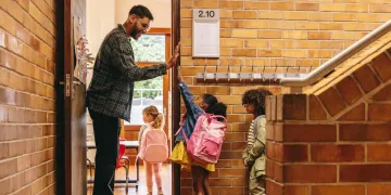 male teacher giving students high five