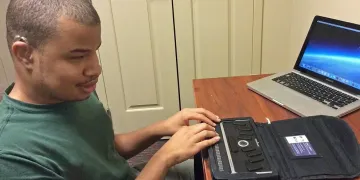Billy Pickens at desk using technology