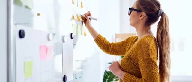 Woman writing on a white board 