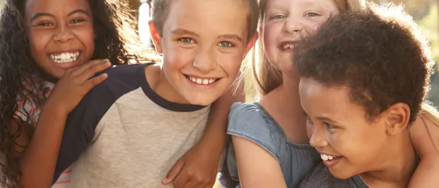 Diverse group of young boys and girls hugging