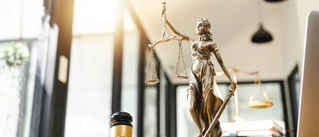Gavel, lady of justice statue, books in an office space