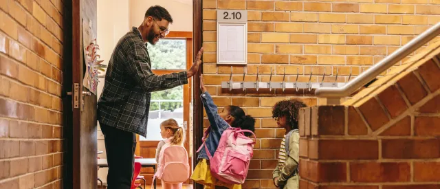 male teacher giving students high five