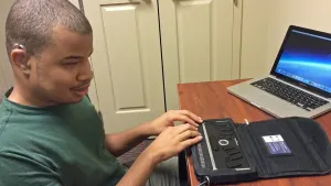 Billy Pickens at desk using technology
